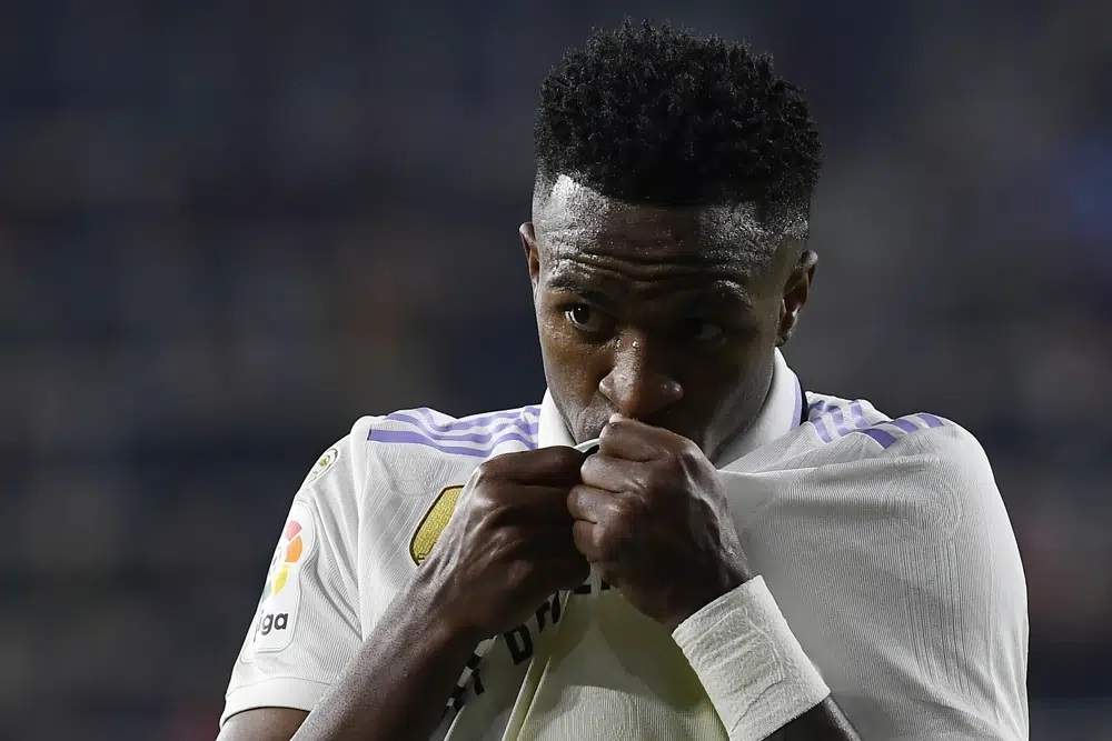 Vinicius Junior del Real Madrid besa el escudo del equipo tras el gol de su compañero Federico Valverde ante Osasuna en la Liga española
