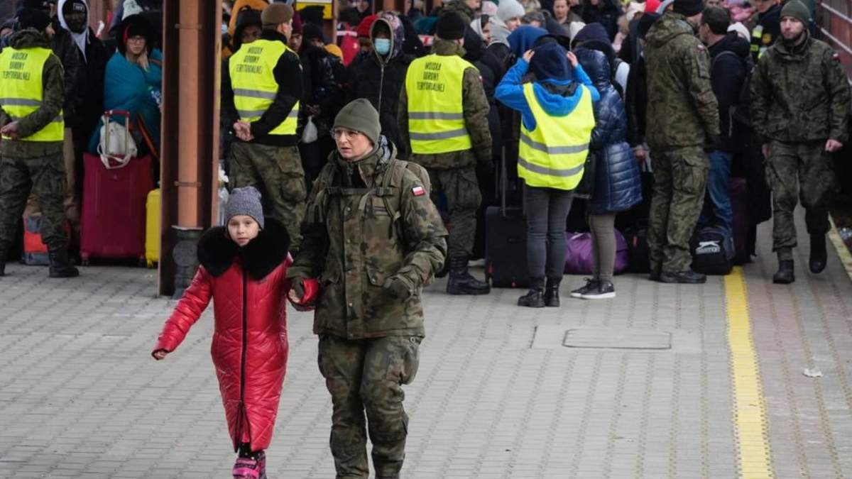 Un soldado acompaña a un niño en una estación de tren llena de refugiados provenientes de Ucrania, en Przemysl, Polonia.