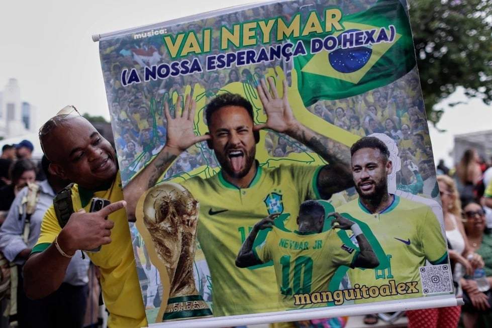 Un aficionado posa con un póster del futbolista brasileño Neymar, que dice en portugués "¡Vamos Neymar, nuestra esperanza para un sexto título mundial!", antes de que se anuncie la lista de convocados de Brasil para el Mundial de 2026, en Río de Janeiro, el lunes 18 de mayo de 2026.