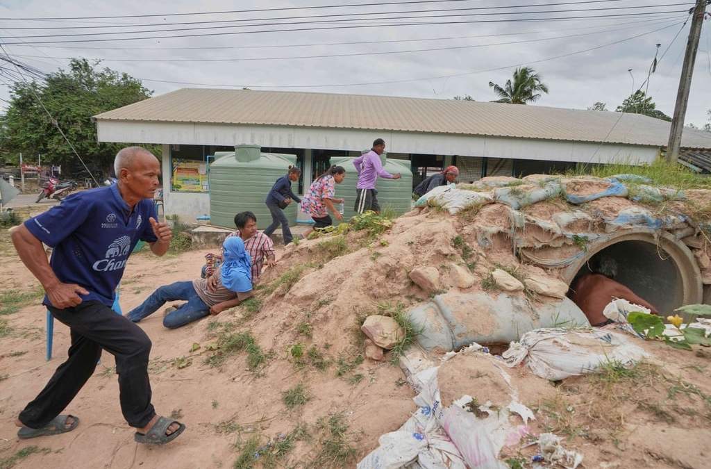 Voluntarios encargados de la seguridad y residentes corren a refugiarse ante la cercanía de las explosiones, en la provincia de Buriram, Tailandia, el 12 de diciembre de 2025, tras la reanudación de los combates entre Tailandia y Camboya