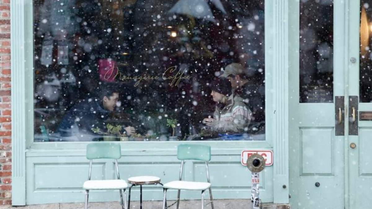 Clientes en el interior de una cafetería mientras nieva en el vecindario de Old City, en Filadelfia, el 19 de enero de 2024