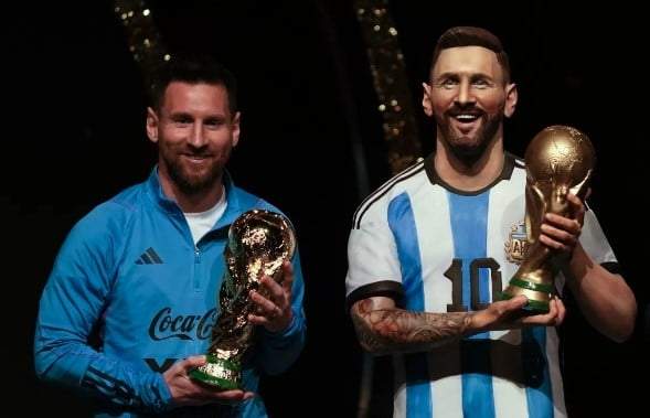 El astro argentino Lionel Messi sostiene una réplica de la Copa Mundial