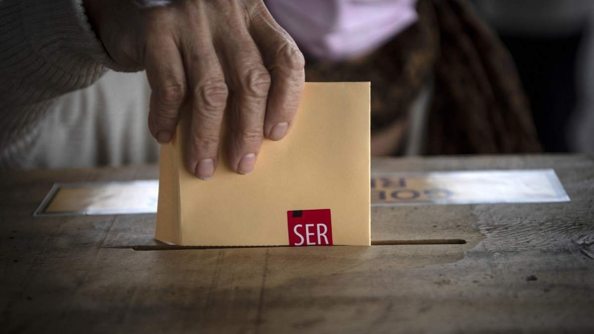 Una persona deposita su voto en una urna electoral en Chile. Fuente: (Twitter)