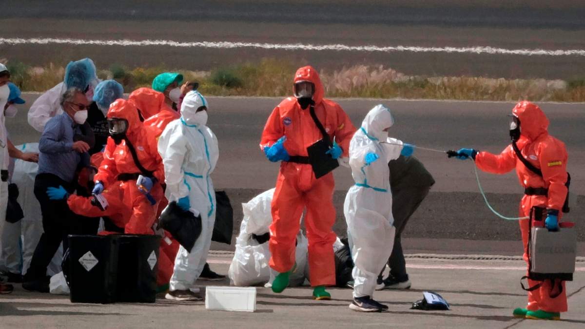 Pasajeros son rociados con desinfectante por personal del gobierno español antes de subir a un barco tras desembarcar del crucero afectado por un brote de hantavirus, el MV Hondius, en el aeropuerto de Tenerife, en las islas Canarias, España