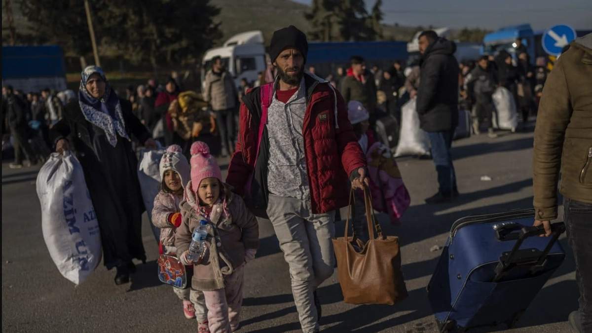 Sirios ingresan a su país desde el punto de cruce turco de Cilvegozu, en Reyhanli, sureste de Turquía, el sábado 18 de febrero de 2023, casi dos semanas después del fatal sismo