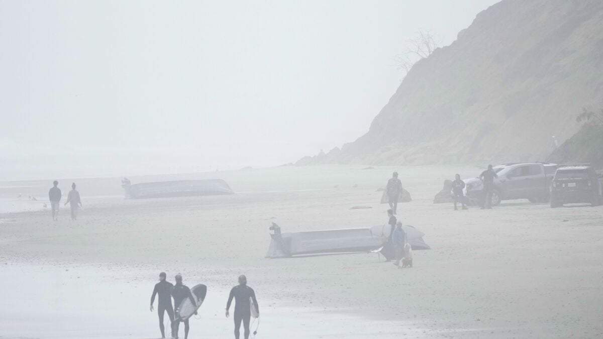 Dos botes, uno de ellos volteado, en Blacks Beach