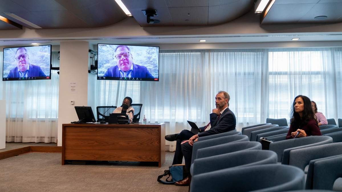 El experto Robert Knop aparece en una pantalla mientras responde preguntas durante una reunión pública de la Comisión Federal de Elecciones sobre IA en publicidad política