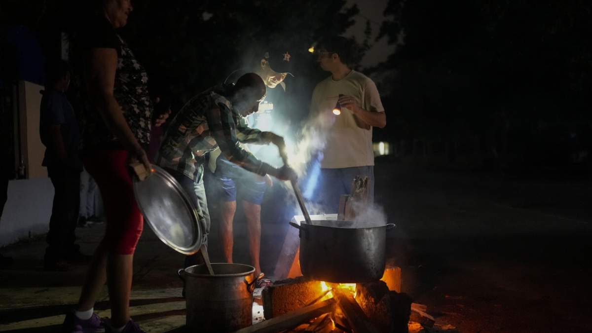 Personas preparan una sopa en una fogata durante un apagón que siguió a la falla de una importante planta energética en La Habana