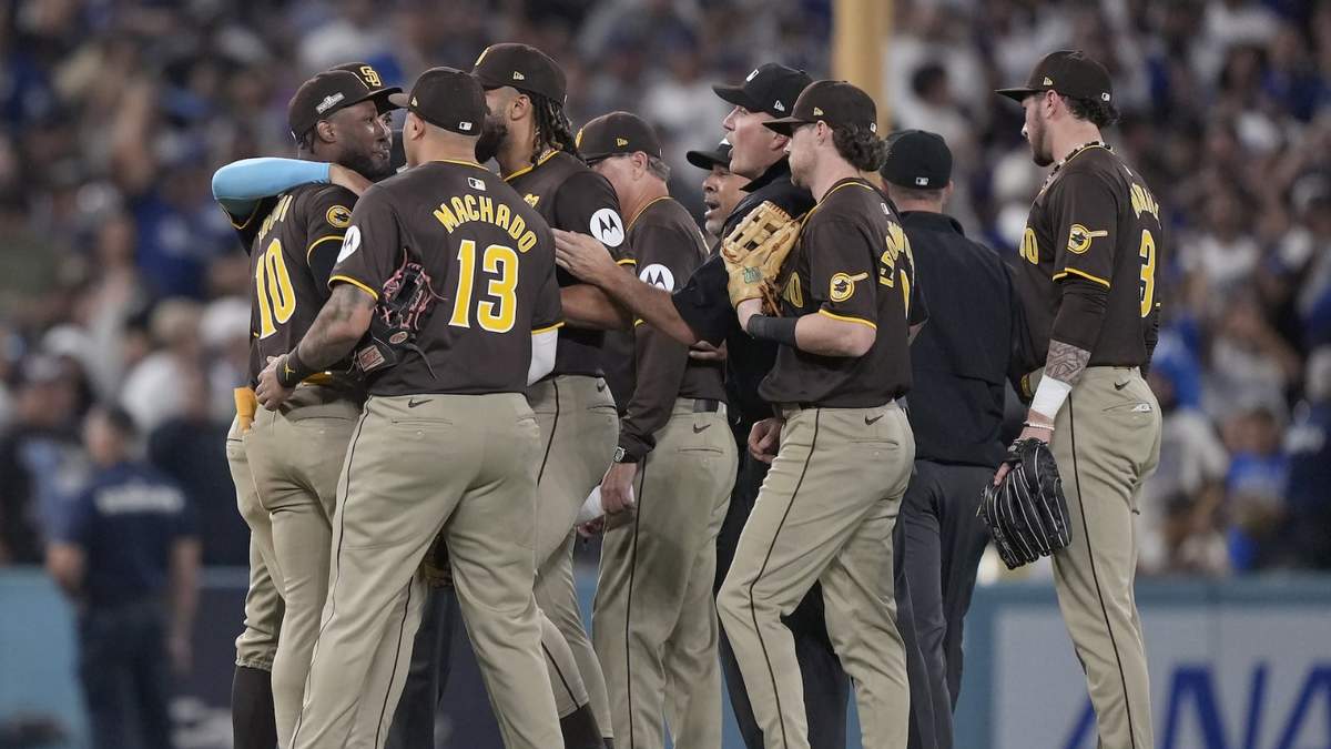 El jardinero Jurickson Profar es retenido por sus compañeros luego de que protestó por la conducta de los aficionados