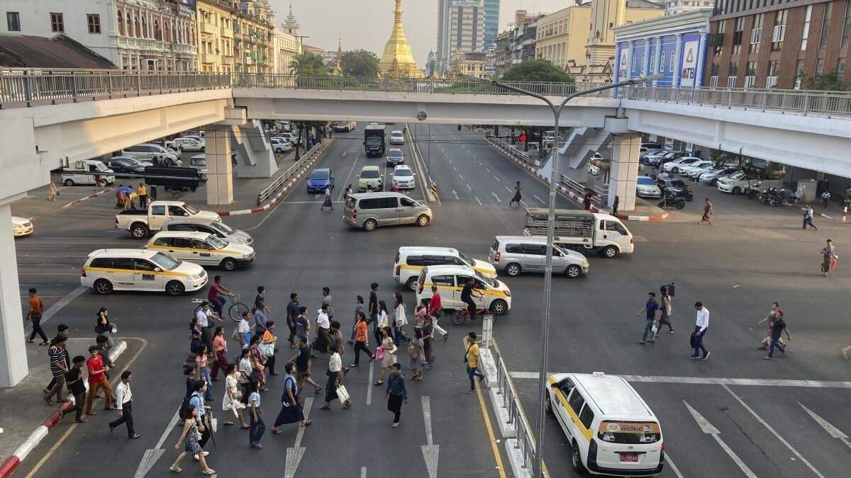 Peatones cruzan una calle cerca de la pagoda Sule en Yangon, Myanmar