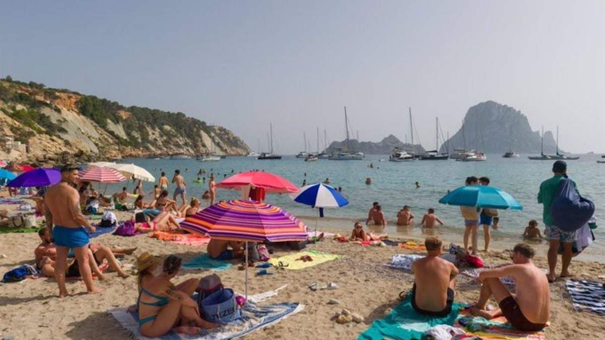 Varias personas en la playa de Cala d'Hort en Ibiza, Islas Baleares, el 11 de julio de 2023