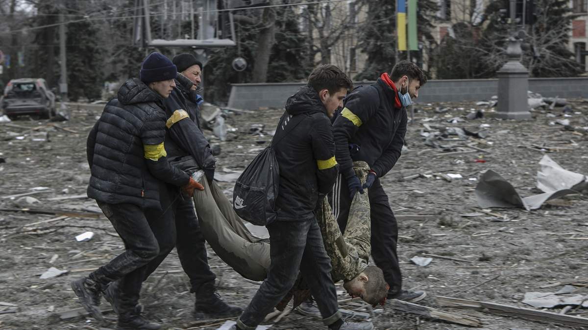 Voluntarios ucranianos rescatan el cuerpo de una víctima del bombardeo al edifico del Ayuntamiento en Kharkiv, Ucrania.