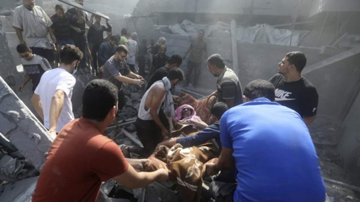 Palestinos rescatan a una mujer de los escombros de un edificio derrumbado