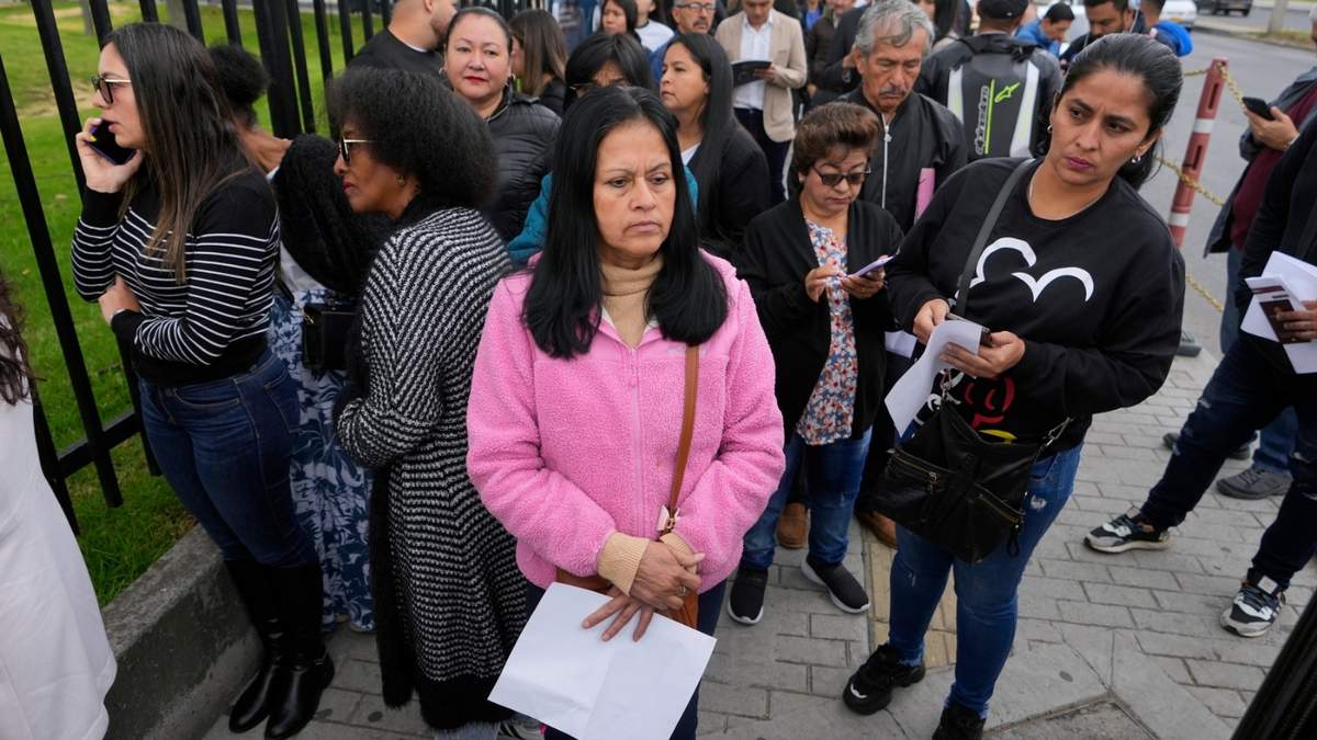 Gloria Camacho sostiene una notificación que indica que su cita para la visa fue cancelada afuera de la embajada de ese país en Bogotá, Colombia