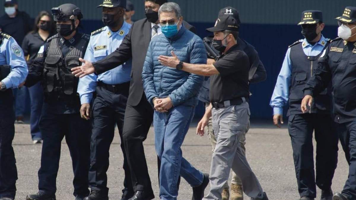 Juan Orlando Hernández es llevado esposado a un avión que lo espera para ser extraditado a EU