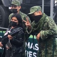 Asistentes al desfile posan con armas prestadas por militares y se desatan críticas en redes