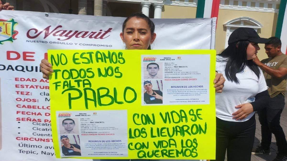 Madre de Pablo Joaquín sostiene una cartulina con información de su hijo desaparecido