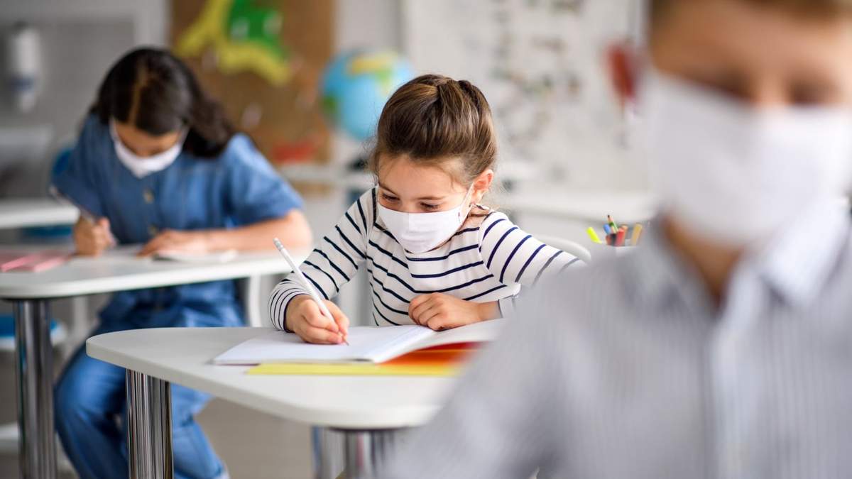 Niños portan mascarillas sanitarias en un salón de clases en Reino Unido. Fuente: (Twitter)