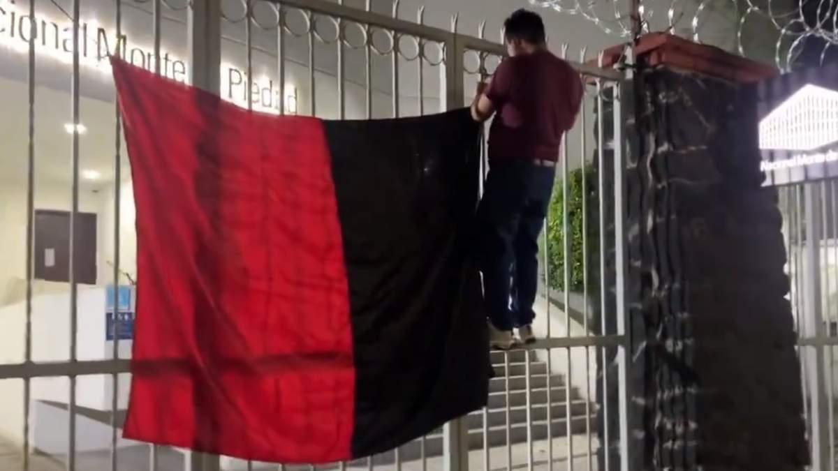 Colocación de una bandera en una sucursal del Nacional Monte de Piedad