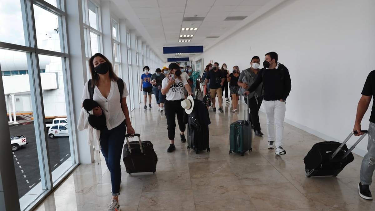 Turistas llegan al aeropuerto de Cancún antes de la llegada del huracán Grace