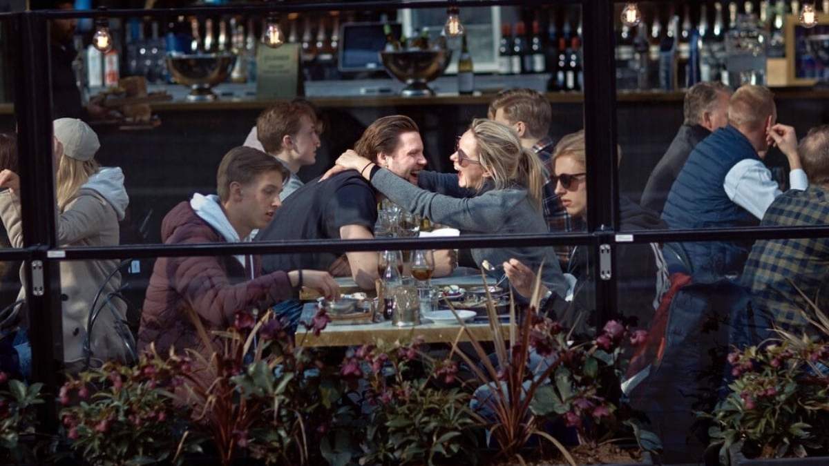 Una pareja se abraza y se ríe mientras almuerzan en un restaurante en Estocolmo, Suecia