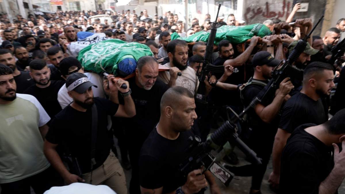 Dolientes marchan durante un funeral con los cadáveres envueltos en la bandera de Hamás y asesinados en un ataque israelí en el campamento de refugiados de Jenin, Cisjordania