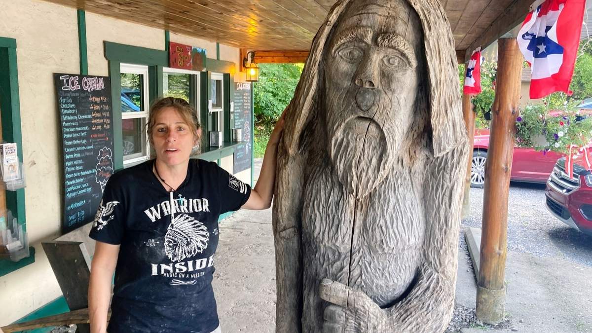Pauline Bauer se apoya en una escultura de madera en Bob's Trading Post, su restaurante en Hamilton Pennsylvania, en 2021
