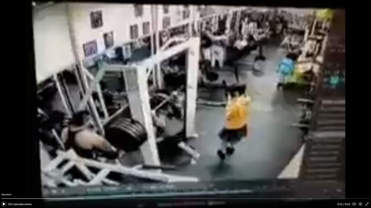 Mujer intenta cargar pesas en el Gym Fitness Sport