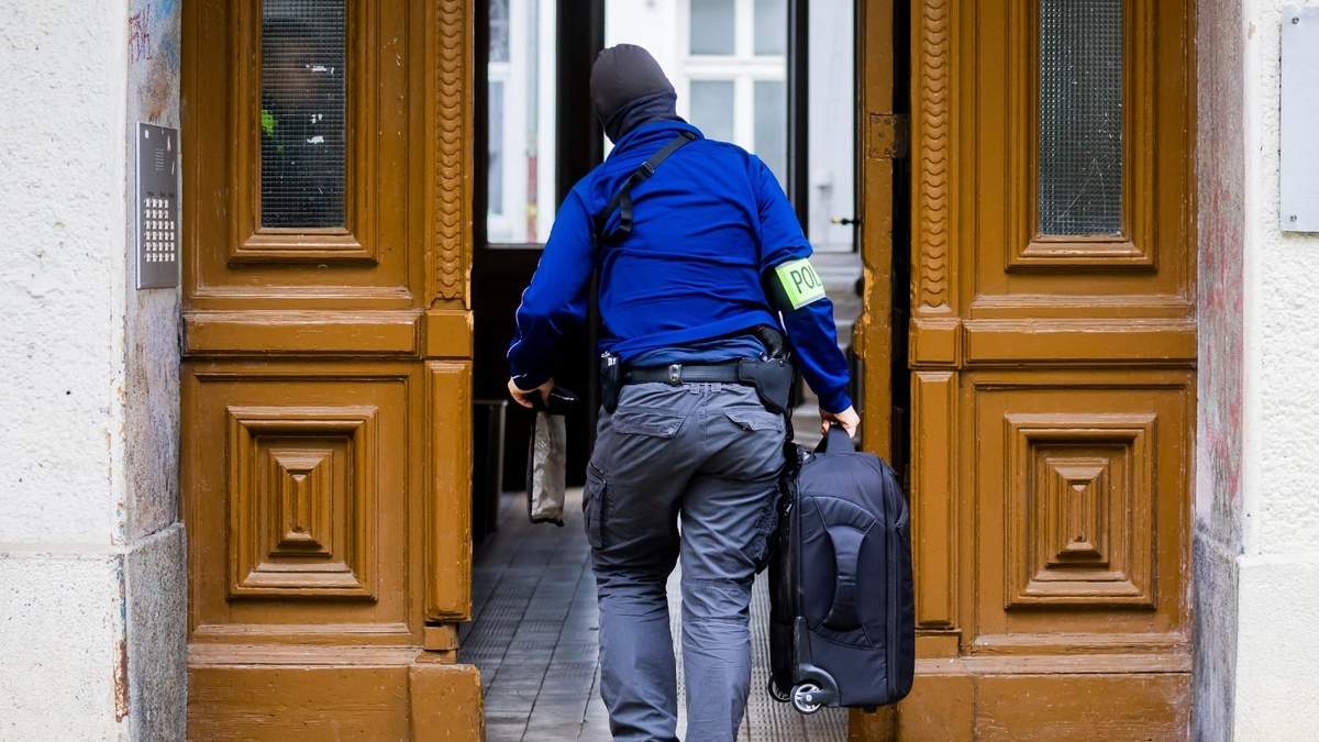 Un policía entra en una casa durante una redada en Berlín