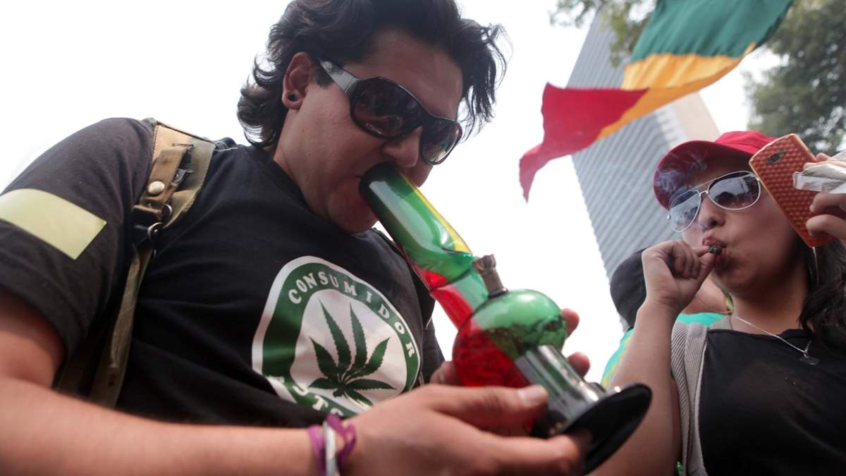 Personas consumen marihuana durante una movilización en favor de la legalización de esta sustancia