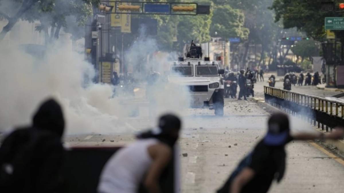 Manifestantes se enfrentan con la policía un día después de los comicios en Caracas, Venezuela