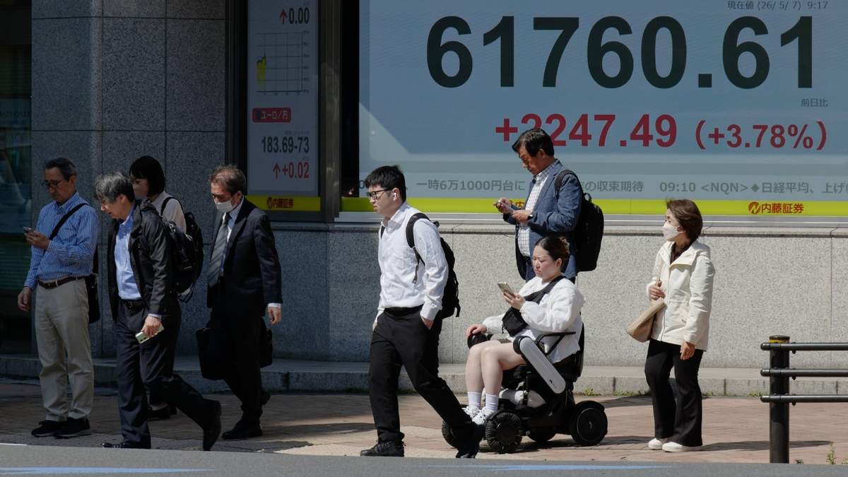 Varias personas caminan en Tokio frente a una pantalla electrónica que muestra el índice Nikkei de Japón en una correduría de valores el jueves 7 de mayo de 2026