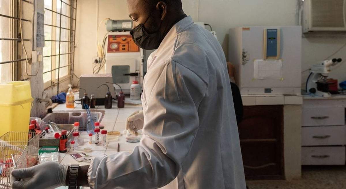 Un médico revisando una muestra en el laboratorio de microbiología de un hospital universitario de Nigeria
