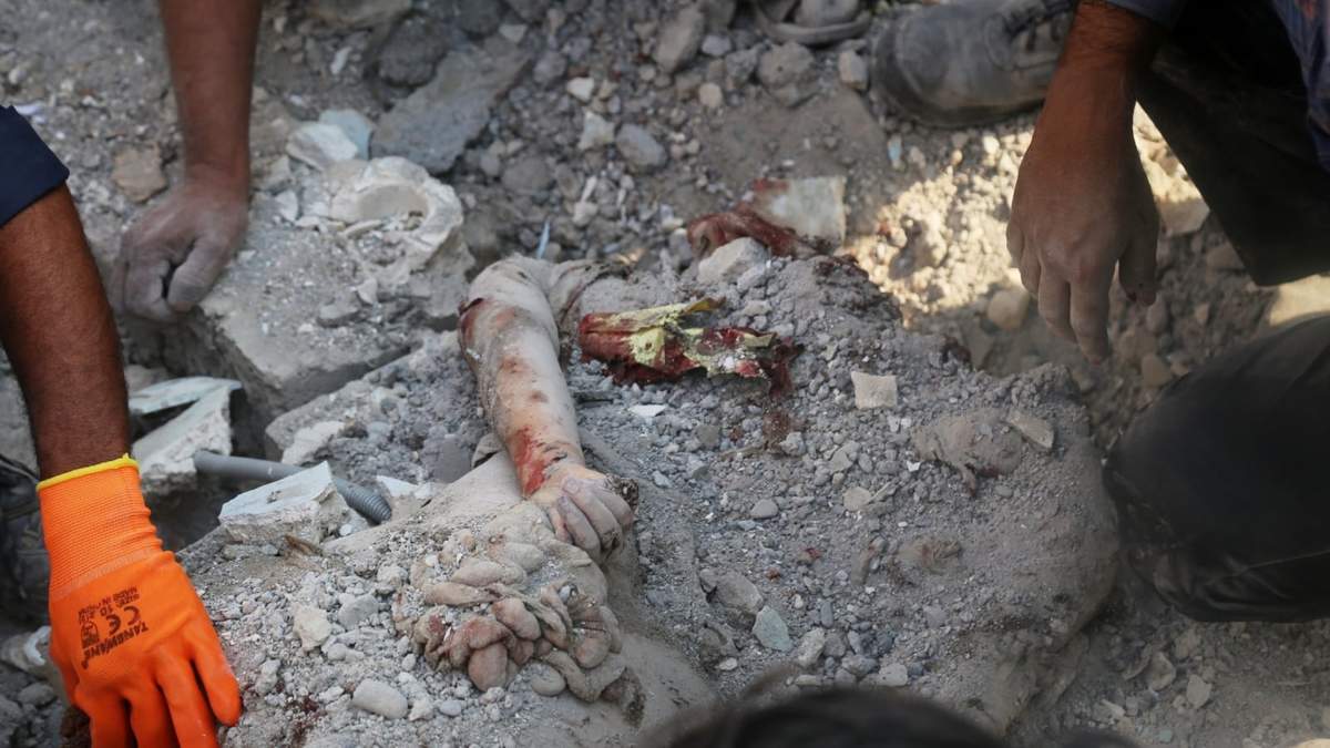 El brazo de una persona fallecida sobresale de los escombros mientras los equipos de rescate y los residentes buscan el sábado 28 de febrero de 2026 entre los restos de una escuela primaria para niñas en Minab, Irán