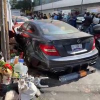 Joven choca su Mercedes Benz contra puestos de comida
