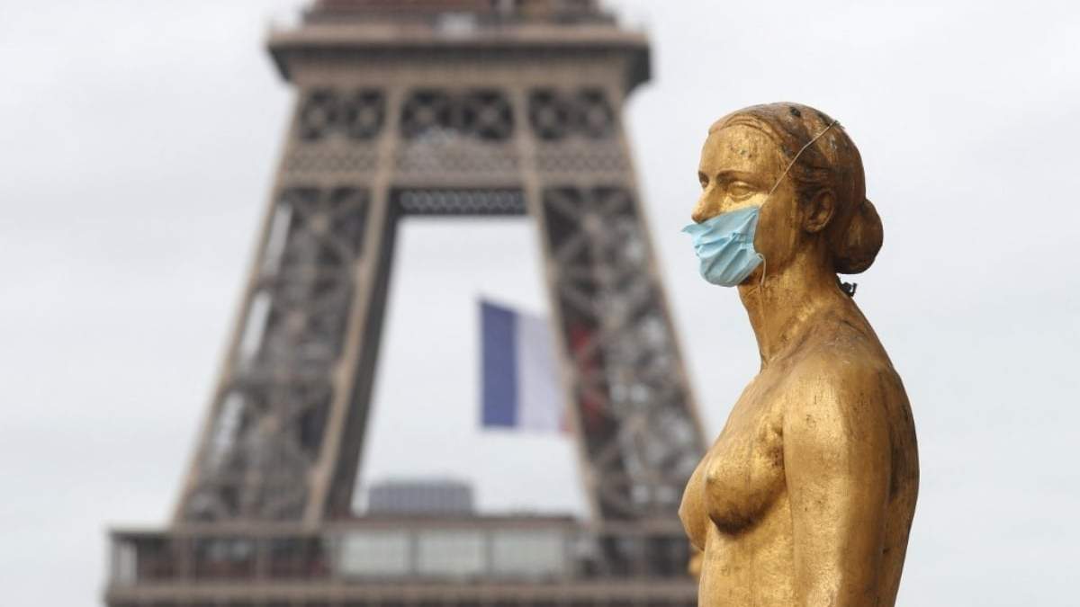 Una estatua con mascarilla frente a la Torre Eiffel en Francia. Fuente: (Twitter)