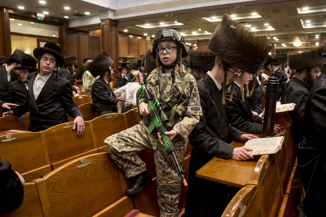 13 de marzo. Hombres y niños judíos ultraortodoxos leen el Libro de Ester, que narra la historia de la festividad judía de Purim, en una sinagoga de Jerusalén. Foto APOhad Zwigenberg.