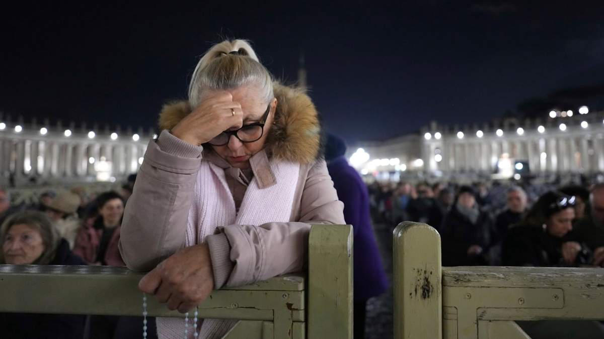 Una mujer participa en el rezo del rosario por la salud del papa Francisco, guiado por el cardenal Víctor Manuel Fernández, en la Plaza de San Pedro del Vaticano