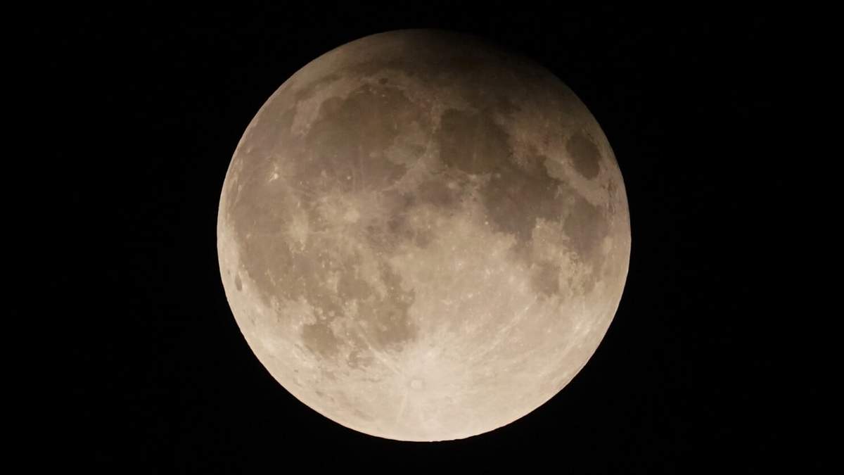 ARCHIVO - Una superluna con eclipse lunar parcial se eleva sobre el lago Michigan en Chicago