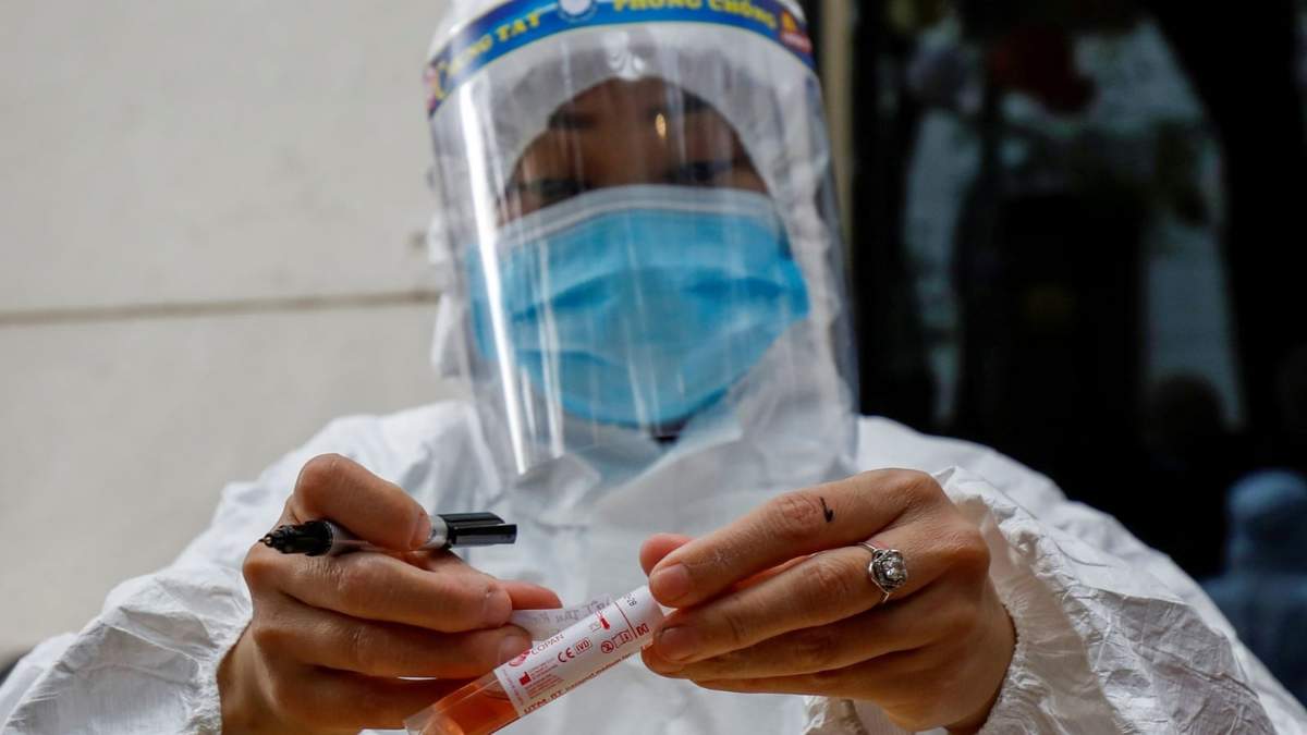 Una sanitaria etiqueta un tubo de ensayo con una muestra biológica del virus. Fuente: (Twitter)