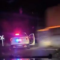 Policía detiene a una mujer, la sube a una patrulla y la arrolla un tren de carga (Video)