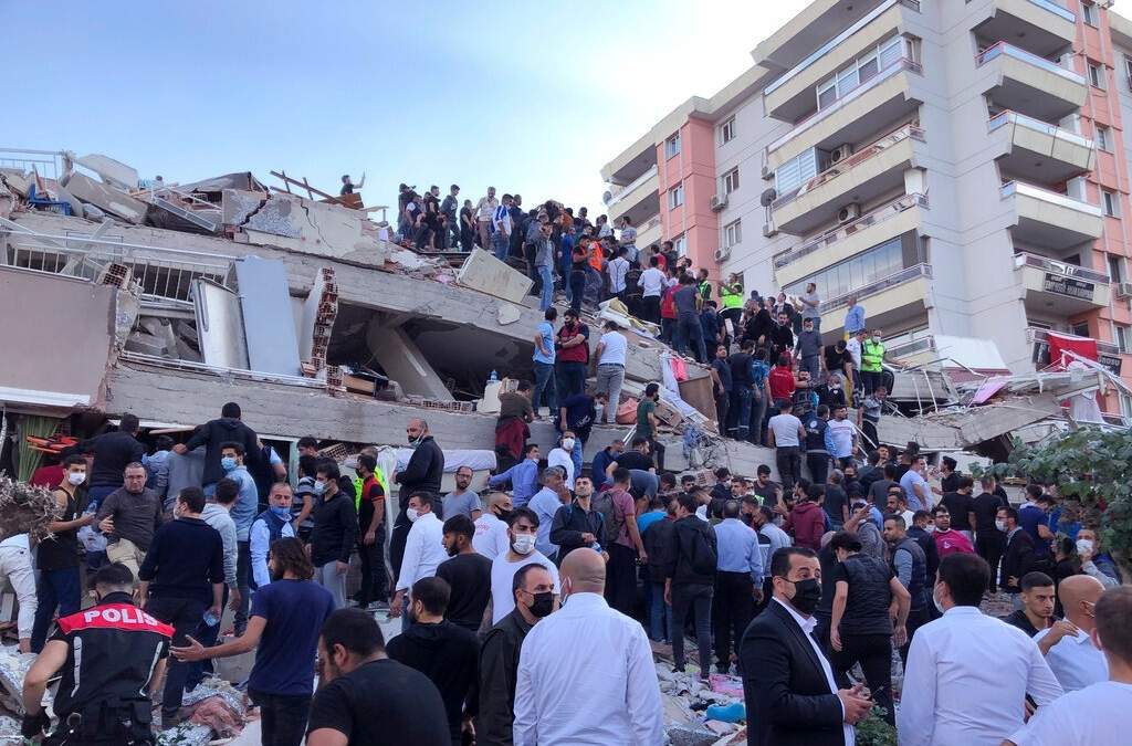Socorristas y residentes intentan rescatar personas bajo los escombros de un edificio en Izmir, Turquía. Foto: AP Ismail Gokmen