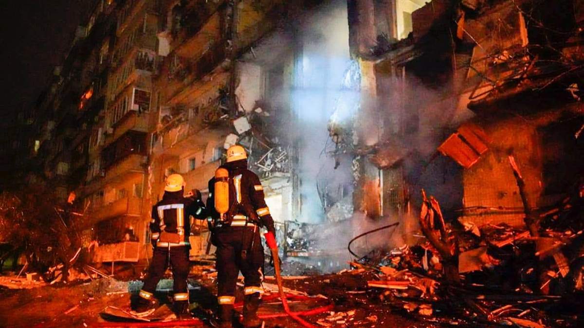 Bomberos inspeccionan los daños de un edificio atacado con cohetes, en Kiev, Ucrania