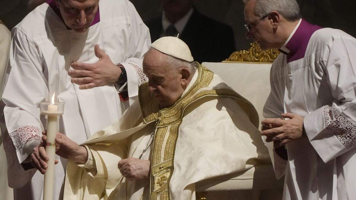 El papa Francisco sostiene un cirio al presidir un oficio de vigilia pascual en la Basílica de San Pedro, sábado 8 de abril de 2023