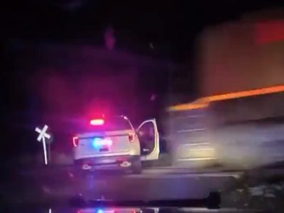 Policía detiene a una mujer, la sube a una patrulla y la arrolla un tren de carga (Video)