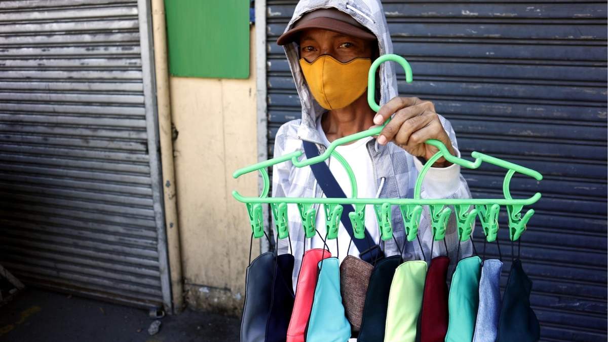 Una vendedora ambulante vende barbijos en la calle. Fuente: (Twitter)
