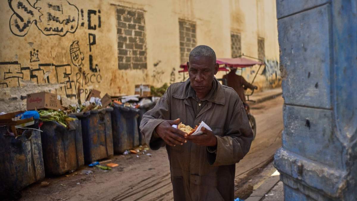 Un hombre come una porción de pizza en La Habana, Cuba