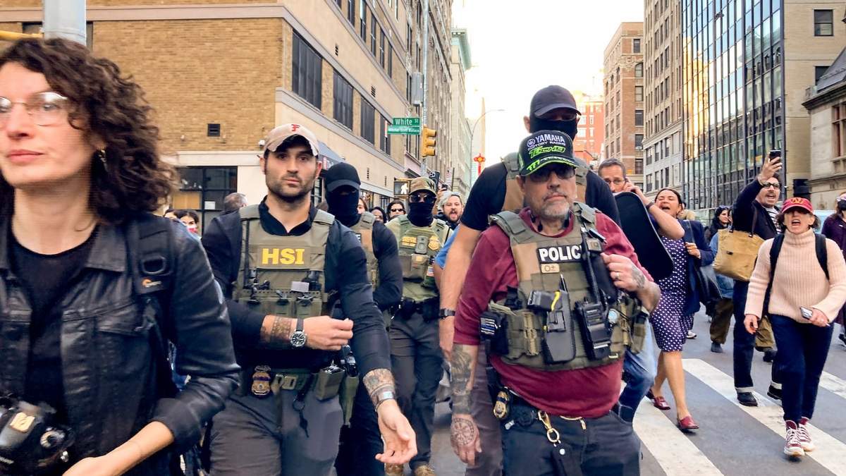 Agentes federales caminan por Lafayette Street seguidos por manifestantes tras una redada de inmigración en Canal Street