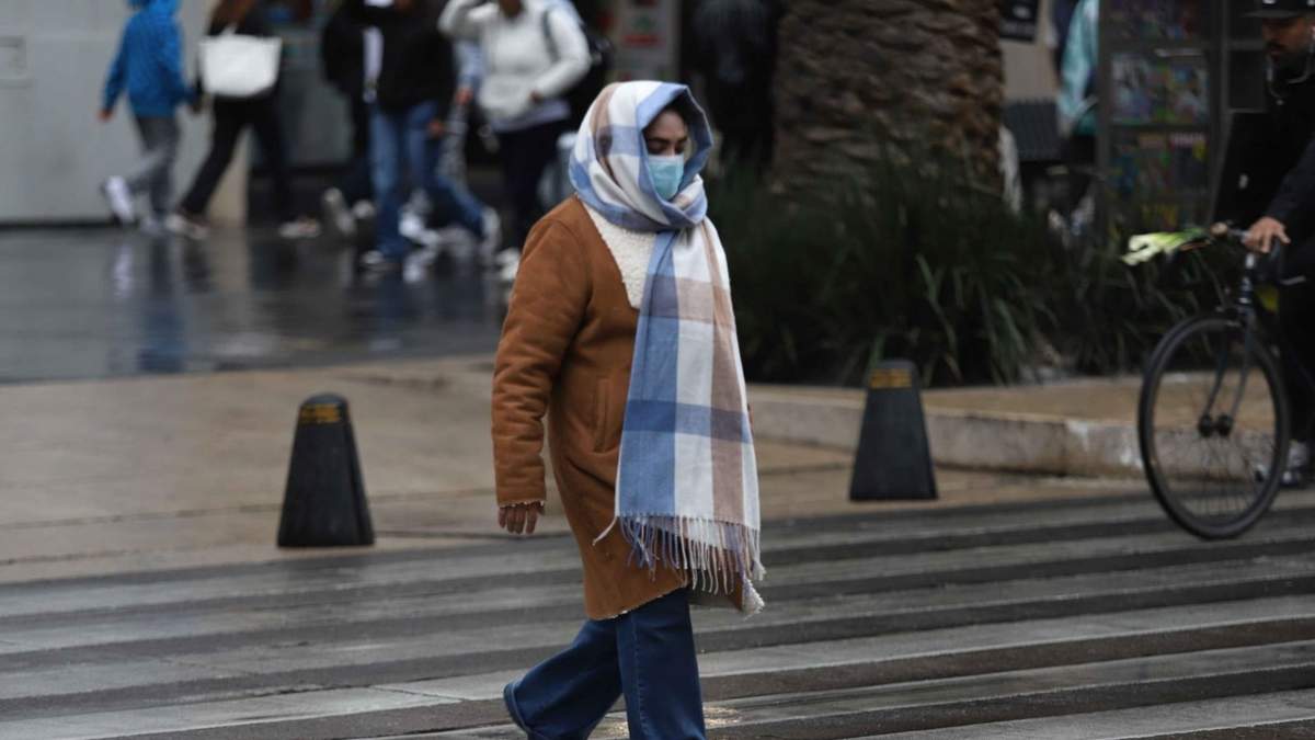 Una mujer se protegió de las bajas temperaturas en Avenida Juárez en CDMX este lunes