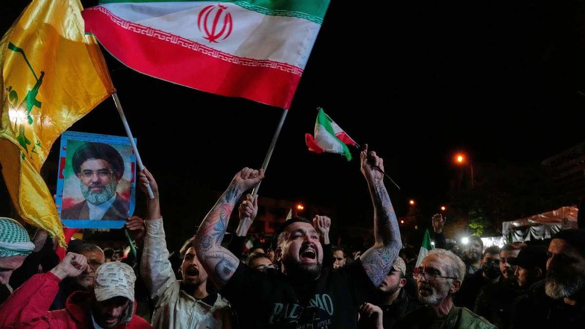 Manifestantes progubernamentales corean eslóganes mientras ondean banderas iraníes y muestran una foto del líder supremo, el ayatolá Mojtaba Jamenei, en una concentración tras el anuncio de una tregua de dos semanas en la guerra con Estados Unidos e Israel